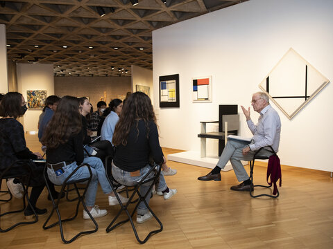 John Walsh and students seated in front ofworks by Mondrian.