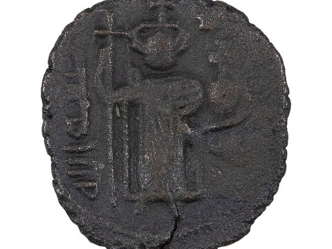 A coin featuring a standing figure in relief alongside symbols or script. The surface appears roughly textured.