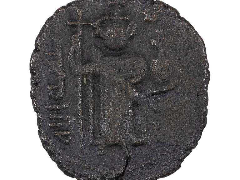 A coin featuring a standing figure in relief alongside symbols or script. The surface appears roughly textured.
