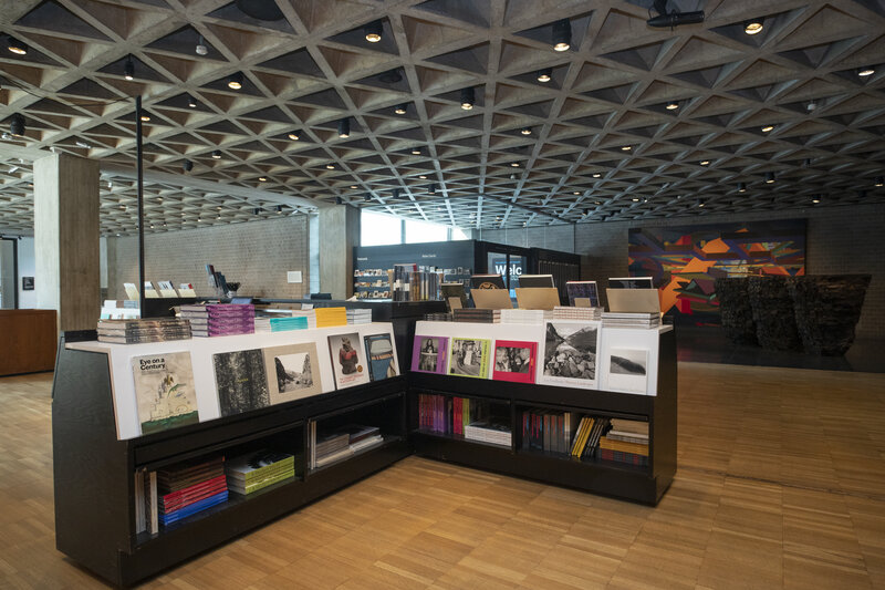 Shelves of books located in a large lobby space with artwork in the background