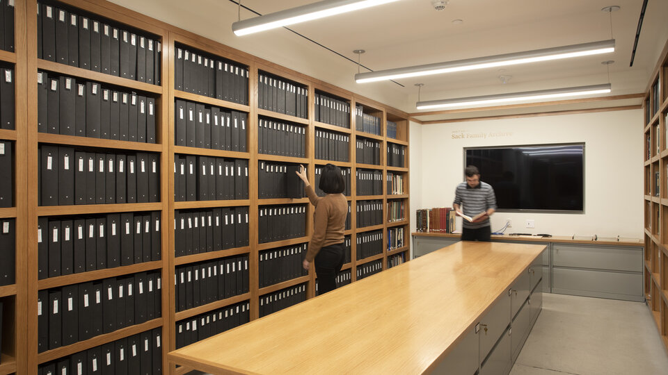Shelves with black binders of archival material. 