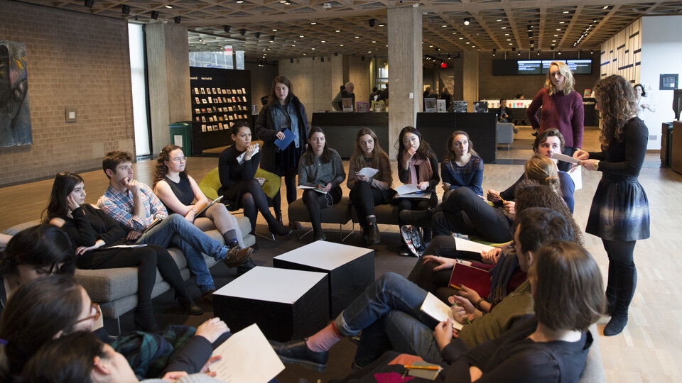 Group of Yale students, women and men, seated on couches in the museum lobby,