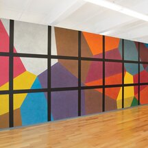 A wall drawing made up of bright, colorful isometric cubes overlaid with a square black grid