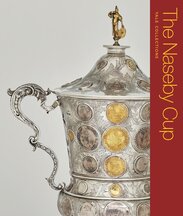 Book cover featuring the top portion of a silver and gold trophy with coins and medals incorporated into it. The book title is listed on a vertical, red background at right.