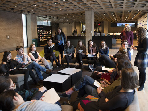 Group of Yale students, women and men, seated on couches in the museum lobby,