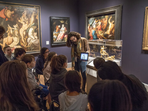 Gallery teacher shows visiting middle school students how a clock they are looking at in the European art galleries works on an iPad. 