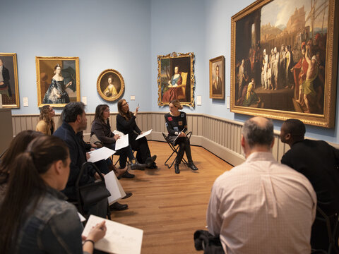 Teachers viewing a landscape painting in the American art galleries during a training session.