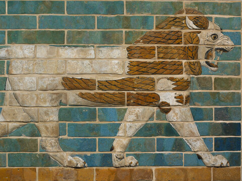 A surface of turquoise bricks on which a lion, with a white body and amber mane, is represented in profile facing right. The animal bears its teeth, its mouth open wide, and appears to walk on a single row of bricks. Its feet, along with other elements, are rendered in relief, projecting toward the viewer.