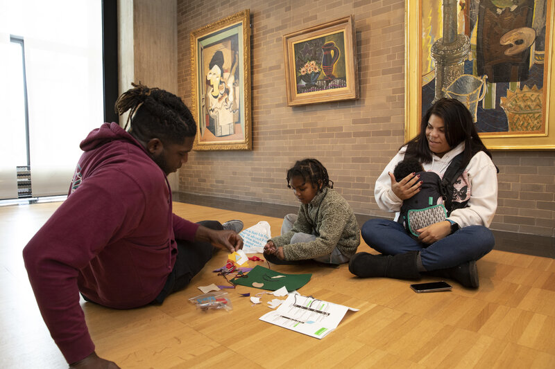 Young boy and his family work on art-making activities during a visit to the Gallery.