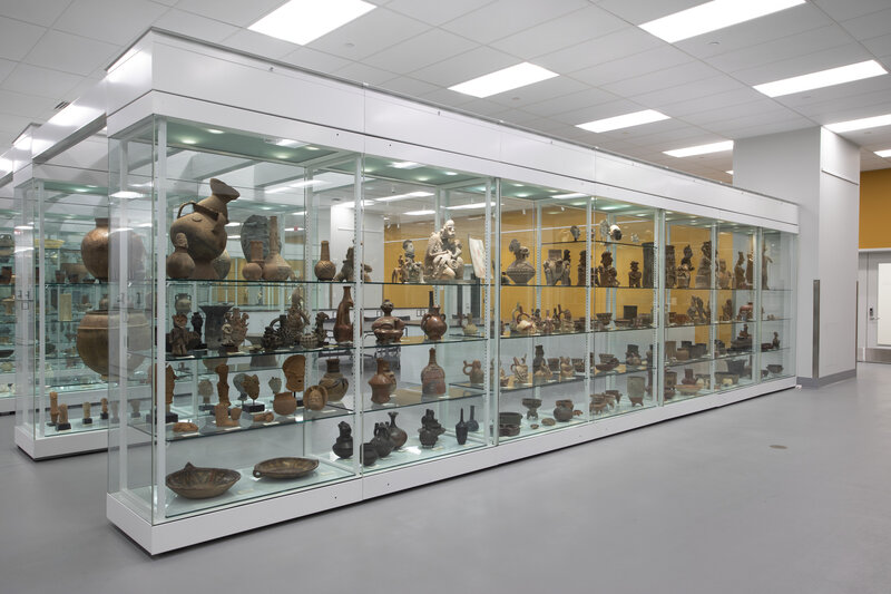 View of rows of glass cases with art objects on four rows of shelves