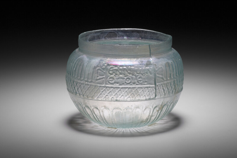 A clear, globe-shaped glass bowl with intricate patterning from the mid-1st century A.D. and the inscription “Ennion made it.”